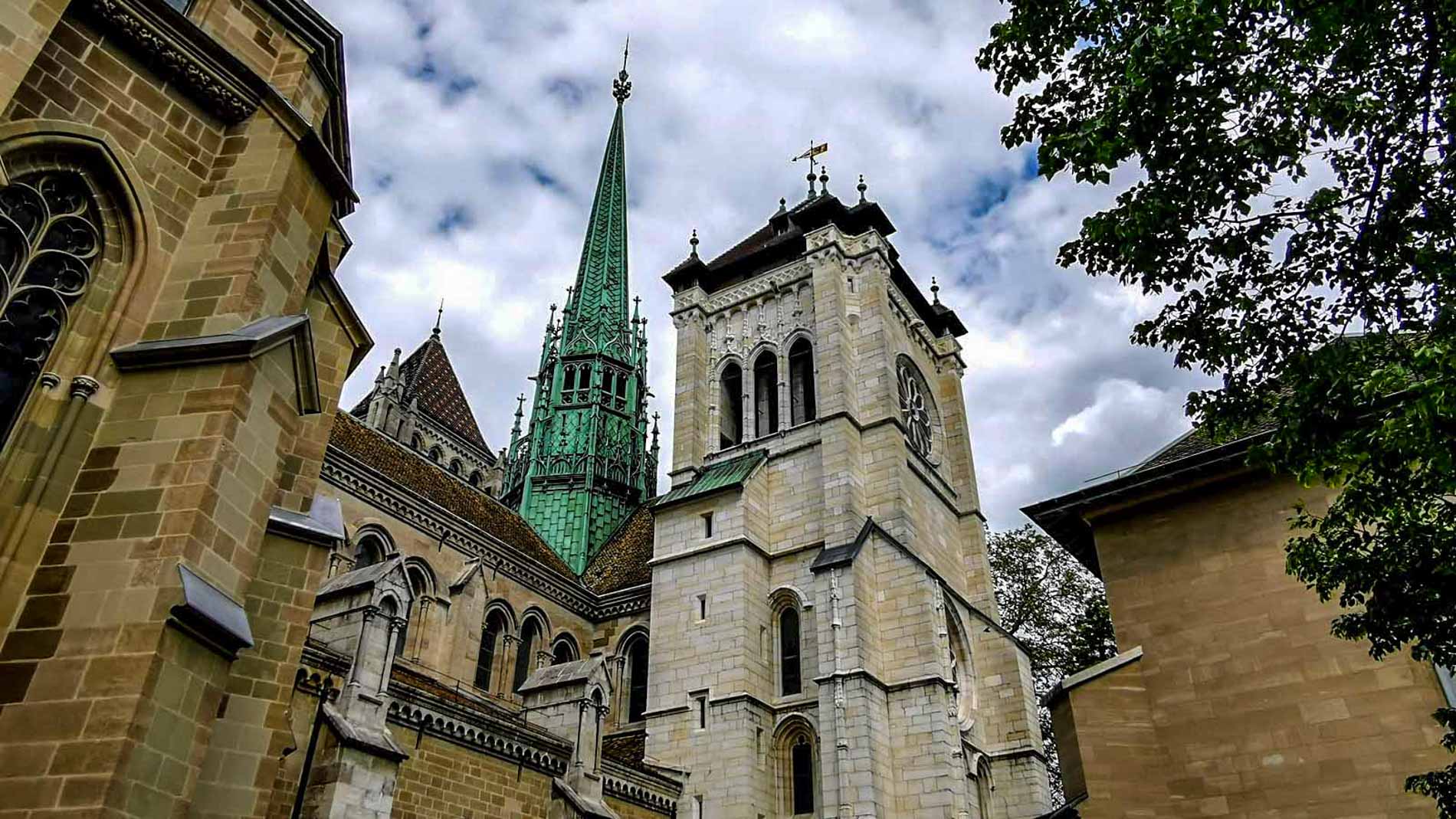 The cathedral of Saint Pierre in Geneva with its  white stone tower and the copper green spire